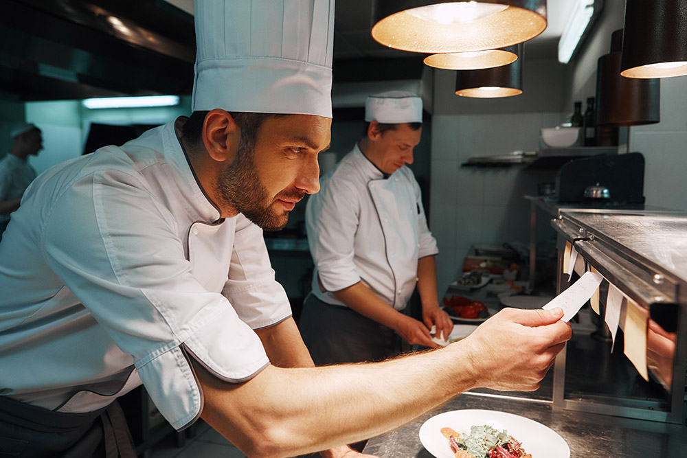 investire nella ristorazione, cuoco che cucina dark kitchen asporto e delivery